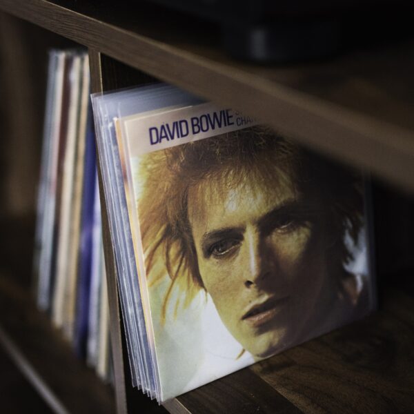 David Bowie 45 RPM picture sleeve stored upright in a clear polyethylene outer sleeve on a wooden record shelf