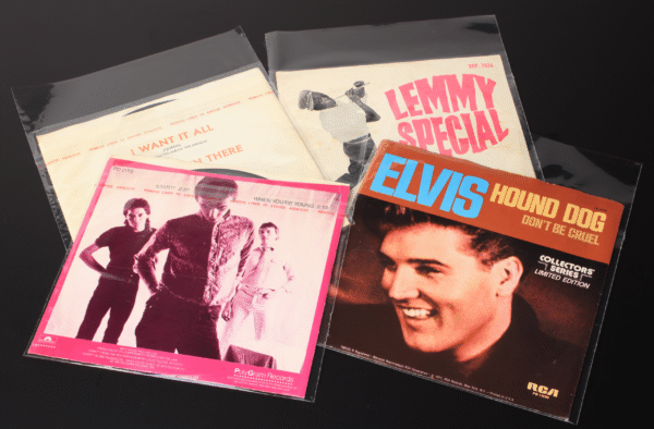 Four 7-inch vinyl records in resealable polypropylene sleeves featuring Elvis, Queen, The Jam, and Lemmy Special